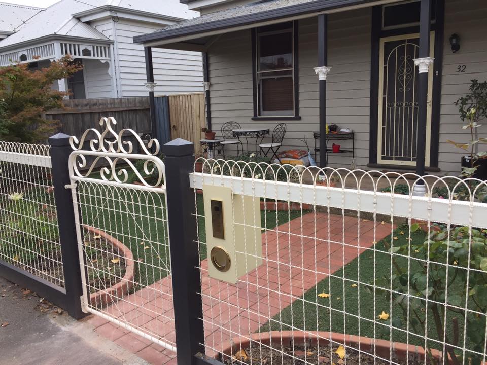 Decorative wrought-iron front gate with scrolled top