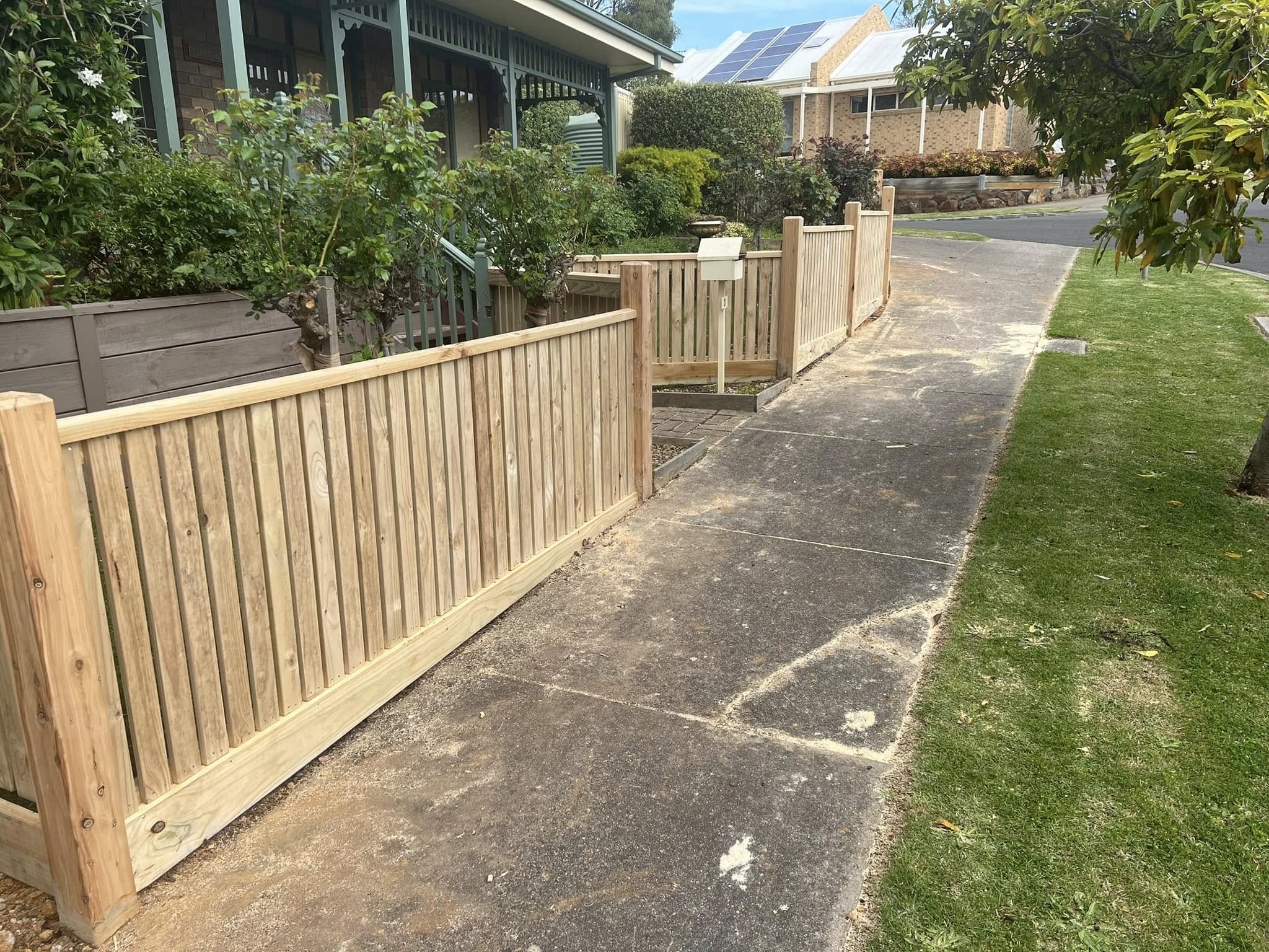 Treated pine paling fence with capping along a residential street