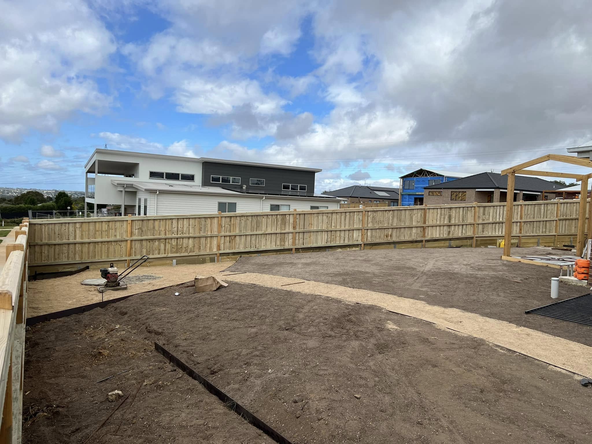 Long stretch of capped paling fencing on a new-build property under a wide Geelong sky