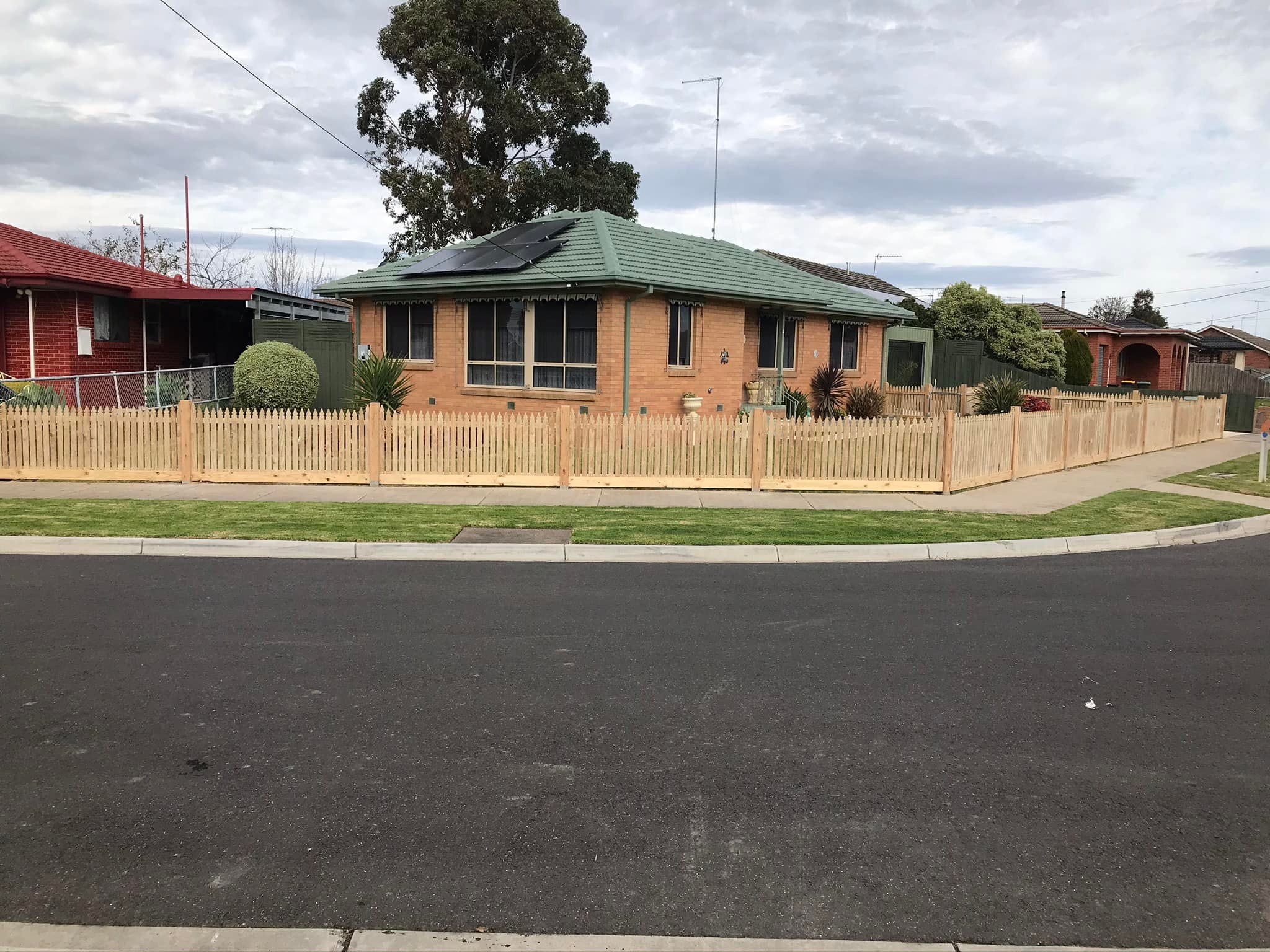 Low picket fence around a brick home