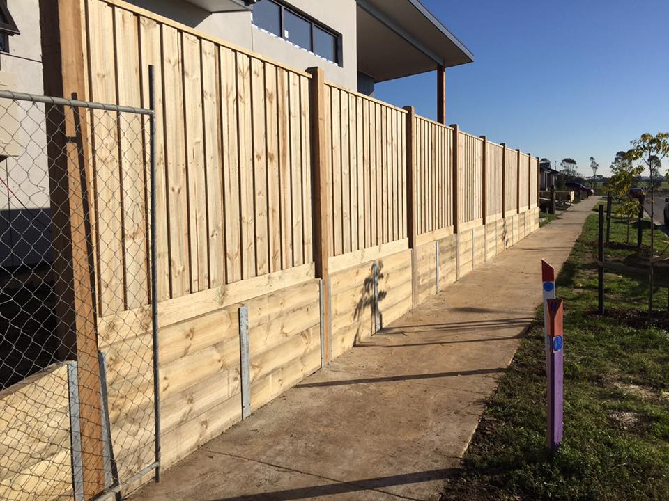 Paling fence reinforced with a new upper section over an existing lower base